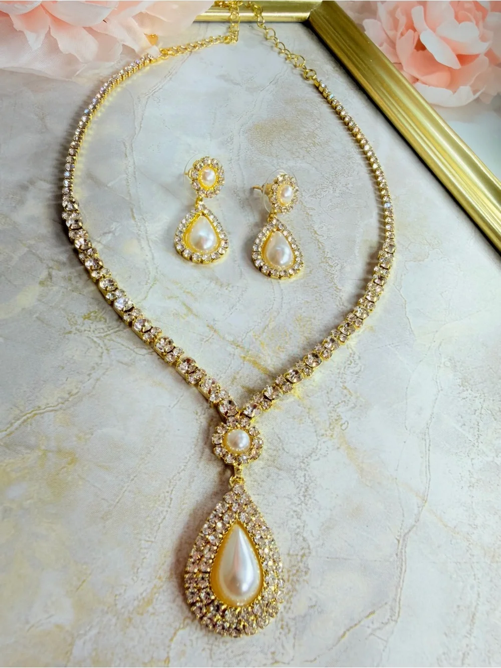 Elegant gold-tone necklace with earrings featuring a white teardrop pearl pendan